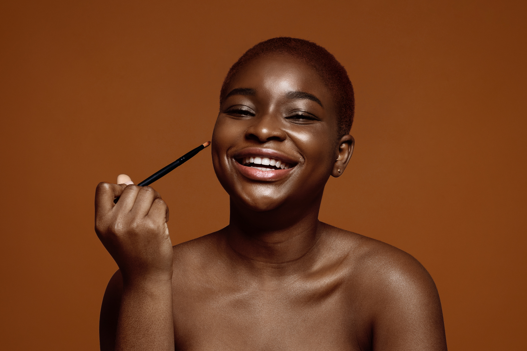Portrait Of Cheerful Black Woman With Short Hair Holding Make Up Brush